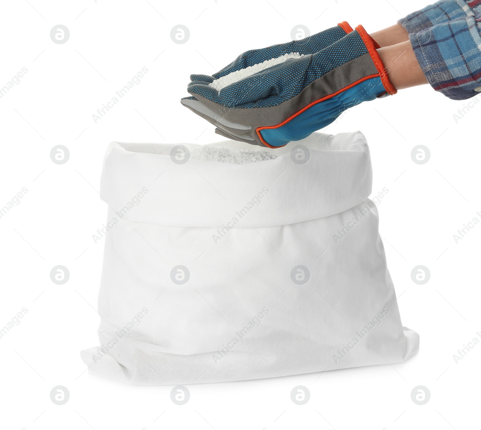 Photo of Man holding ammonium nitrate pellets above sack on white background, closeup. Mineral fertilizer