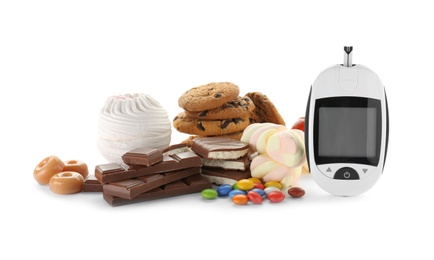 Photo of Digital glucometer and sweets on white background. Diabetes concept