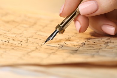 Photo of Woman writing letter with fountain pen, closeup