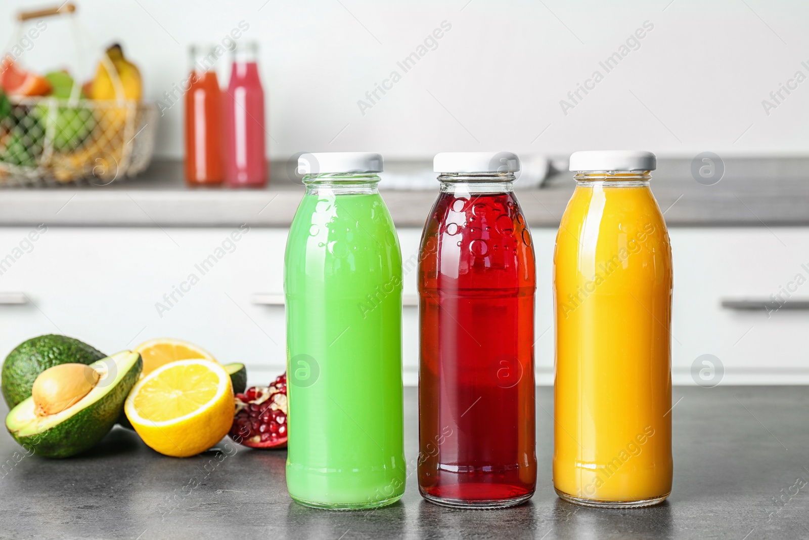 Photo of Bottles with tasty juices and ingredients on table