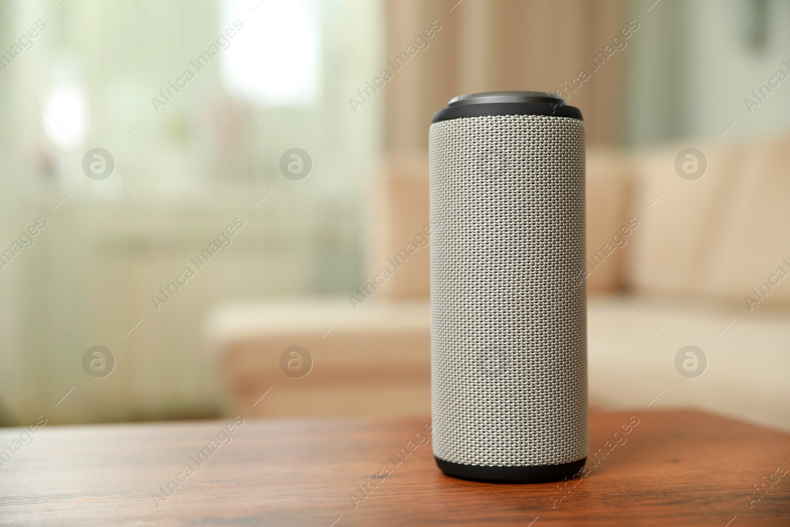 Photo of Portable bluetooth speaker on wooden table indoors, space for text. Audio equipment