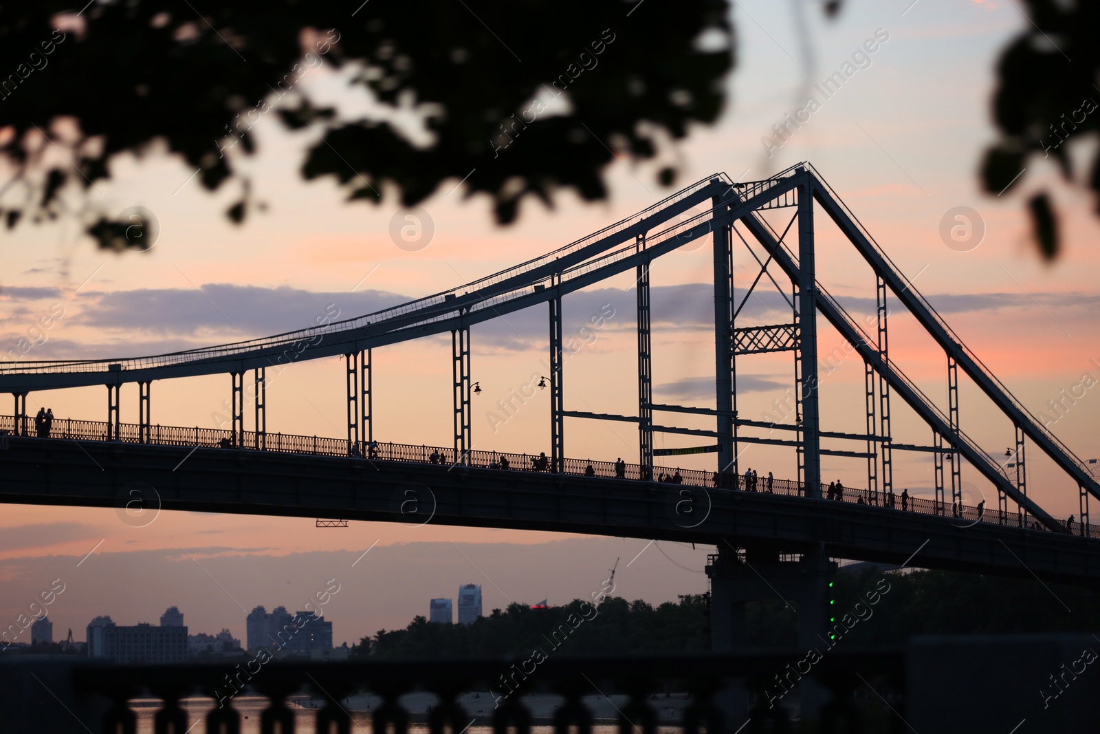 Photo of KYIV, UKRAINE - MAY 23, 2019: Beautiful view of pedestrian bridge over Dnipro river in evening