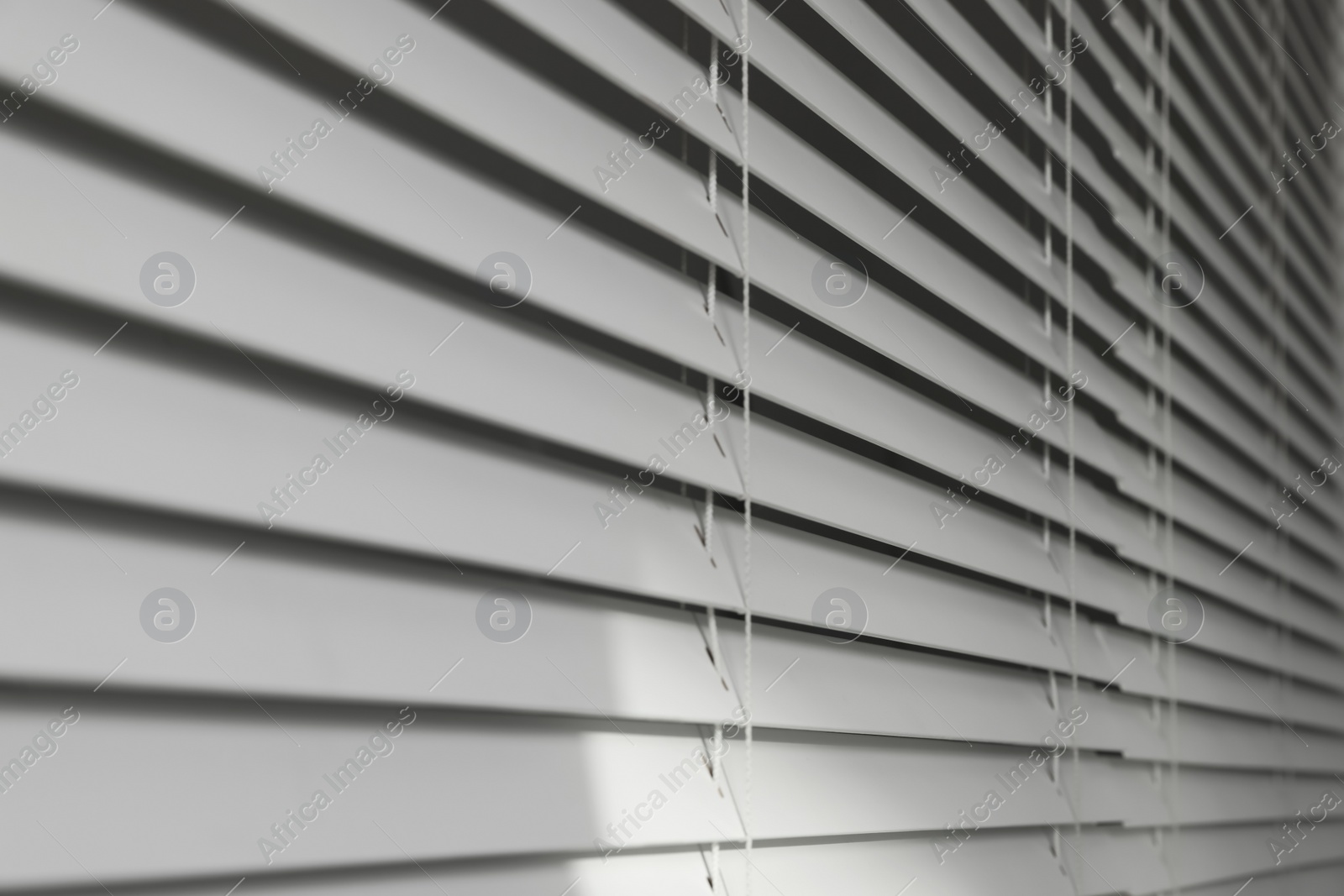 Photo of Closeup view of horizontal blinds on window indoors