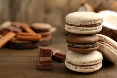 Photo of Delicious macarons and chocolate on wooden table. Space for text