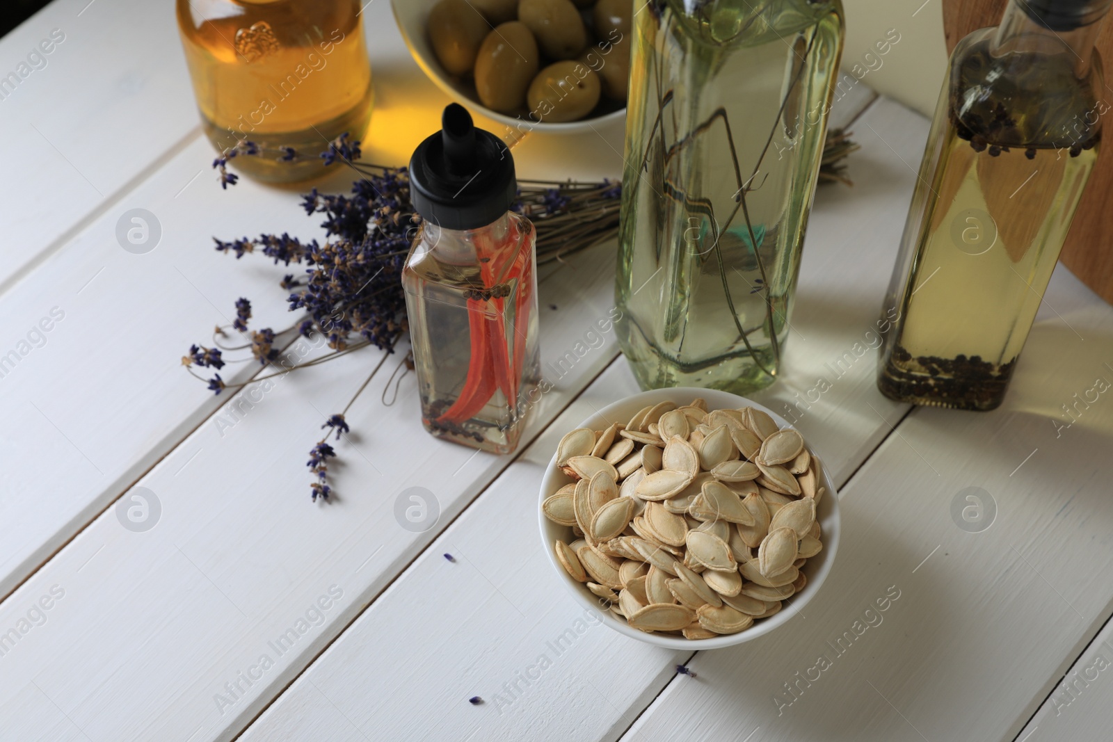 Photo of Different cooking oils and ingredients on white wooden table