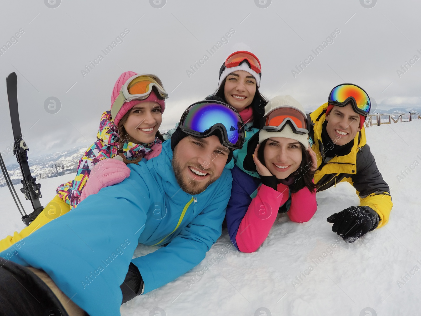 Photo of Group of friends with equipment taking selfie at ski resort. Winter vacation