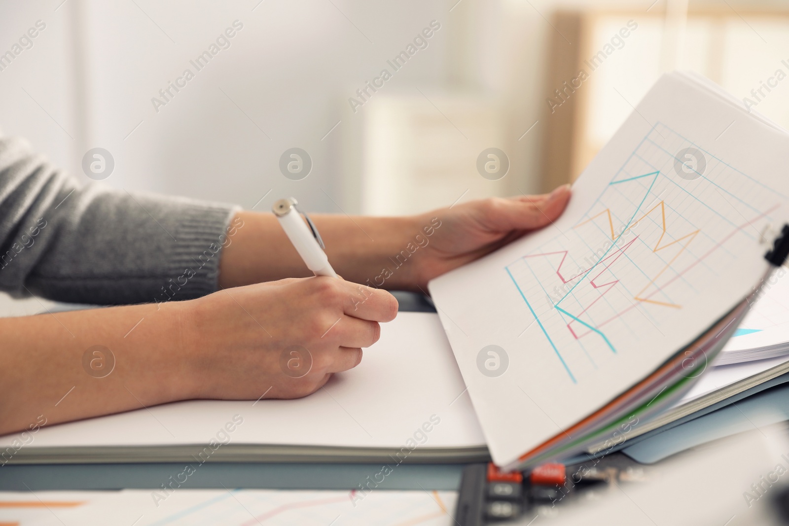 Photo of Office employee working with documents at table, closeup