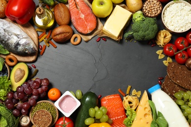 Frame of different products on black table, top view with space for text. Healthy food and balanced diet