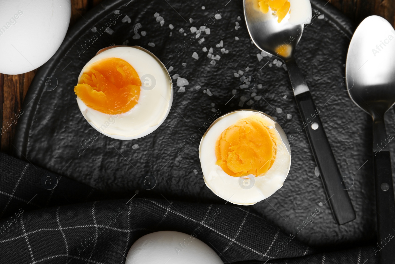 Photo of Tasty boiled chicken eggs on black slate plate, flat lay