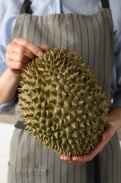 Photo of Woman with whole fresh ripe durian, closeup