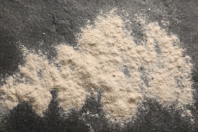 Photo of Scattered flour on grey textured table, top view