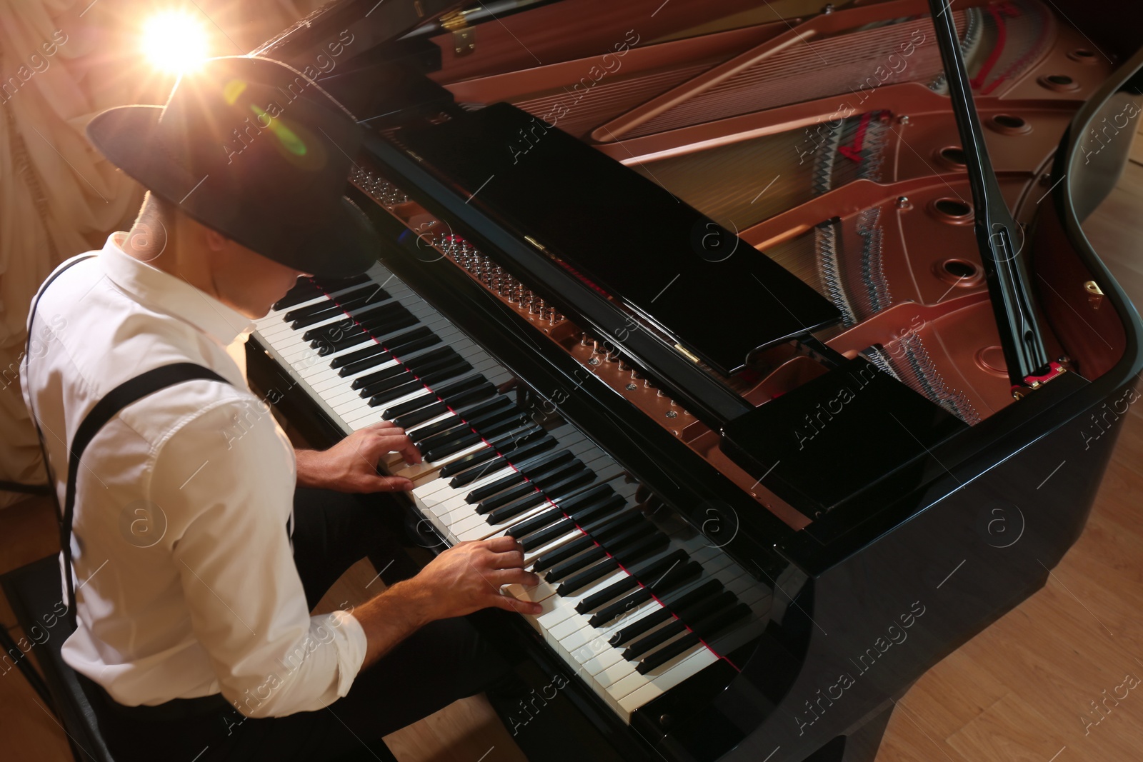 Photo of Man playing piano indoors, above view. Talented musician