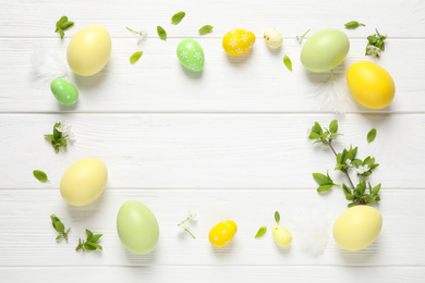 Photo of Frame made with Easter eggs on white wooden background, flat lay. Space for text