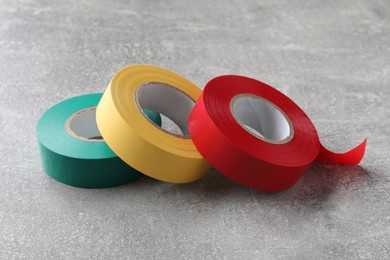 Photo of Colorful insulating tapes on light grey table