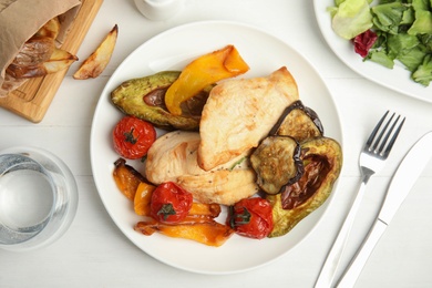 Photo of Tasty cooked chicken fillet and vegetables served on white wooden table, flat lay. Healthy meals from air fryer