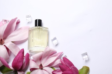 Photo of Beautiful pink magnolia flowers, bottle of perfume and ice cubes on white background, flat lay. Space for text