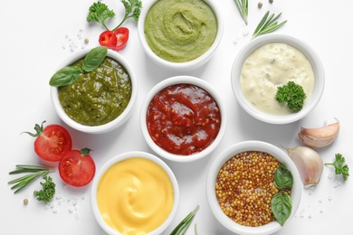 Composition with different sauces and ingredients on white background, flat lay