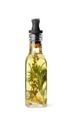 Photo of Glass bottle of cooking oil with spices and herbs isolated on white