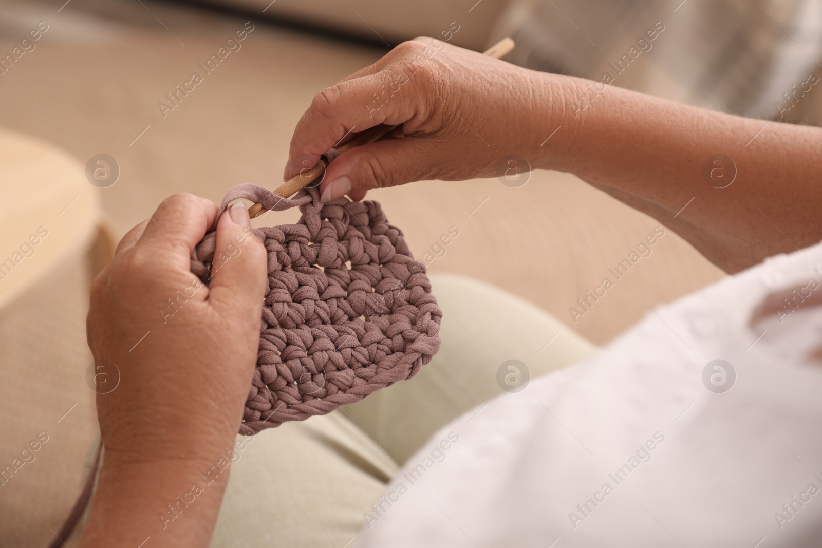 Photo of Elderly woman knitting at home, closeup. Creative hobby