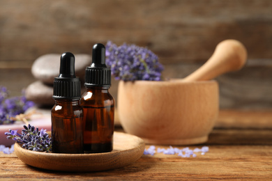 Photo of Cosmetic products and lavender flowers on wooden table. Space for text