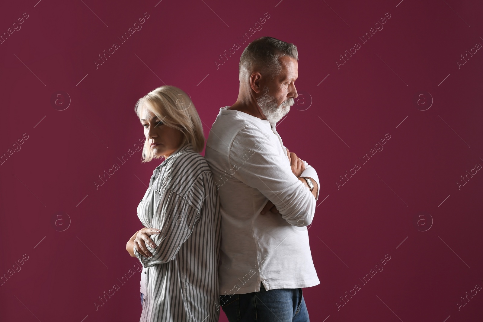 Photo of Upset mature couple on color background. Relationship problems