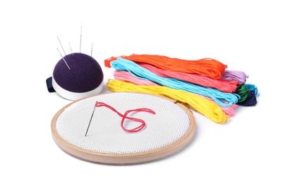 Photo of Colorful threads and different embroidery accessories on white background