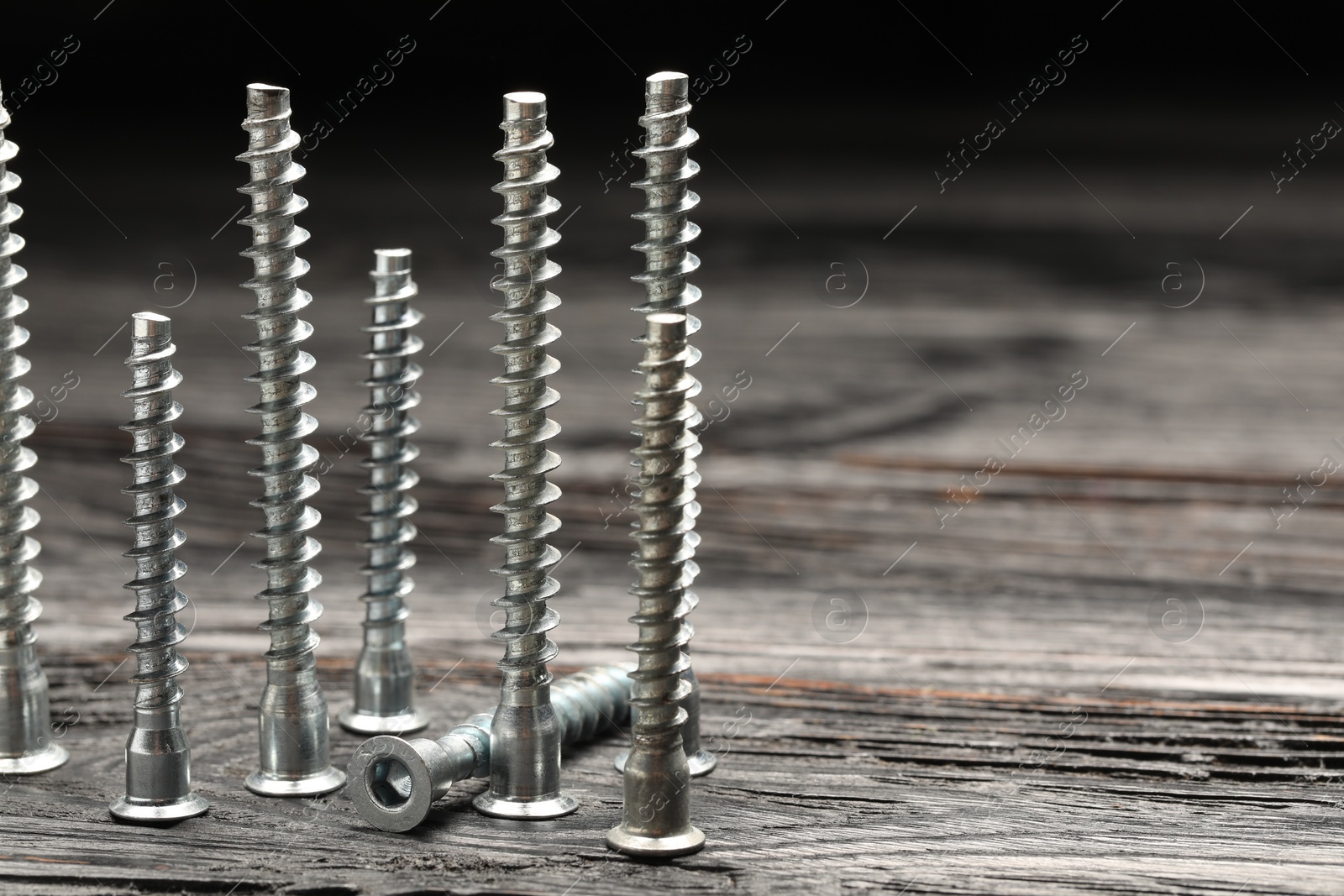 Photo of Countersunk screws on wooden table, closeup. Space for text