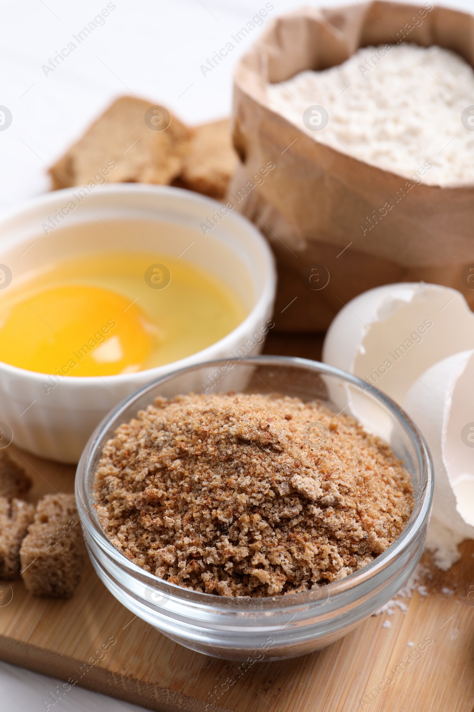 Photo of Fresh breadcrumbs, flour and egg on table