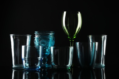 Set of different colorful empty glasses on black background