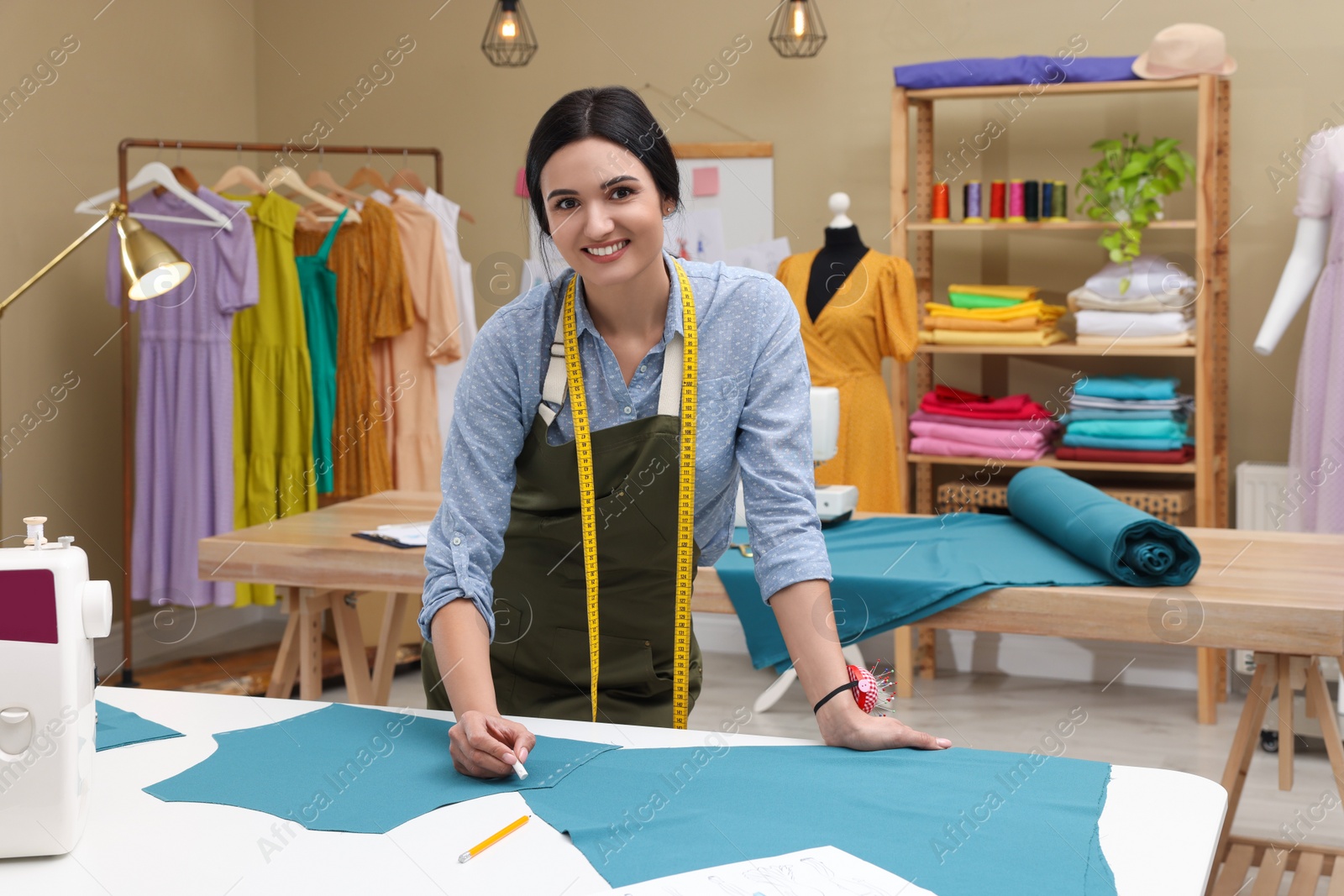 Photo of Dressmaker marking fabric with chalk in workshop