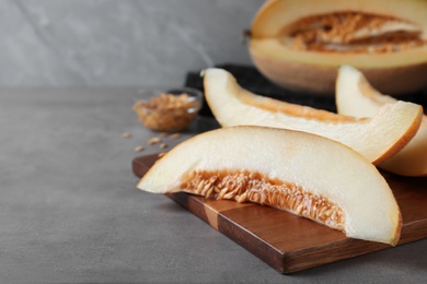 Photo of Slices of delicious honey melon on grey table