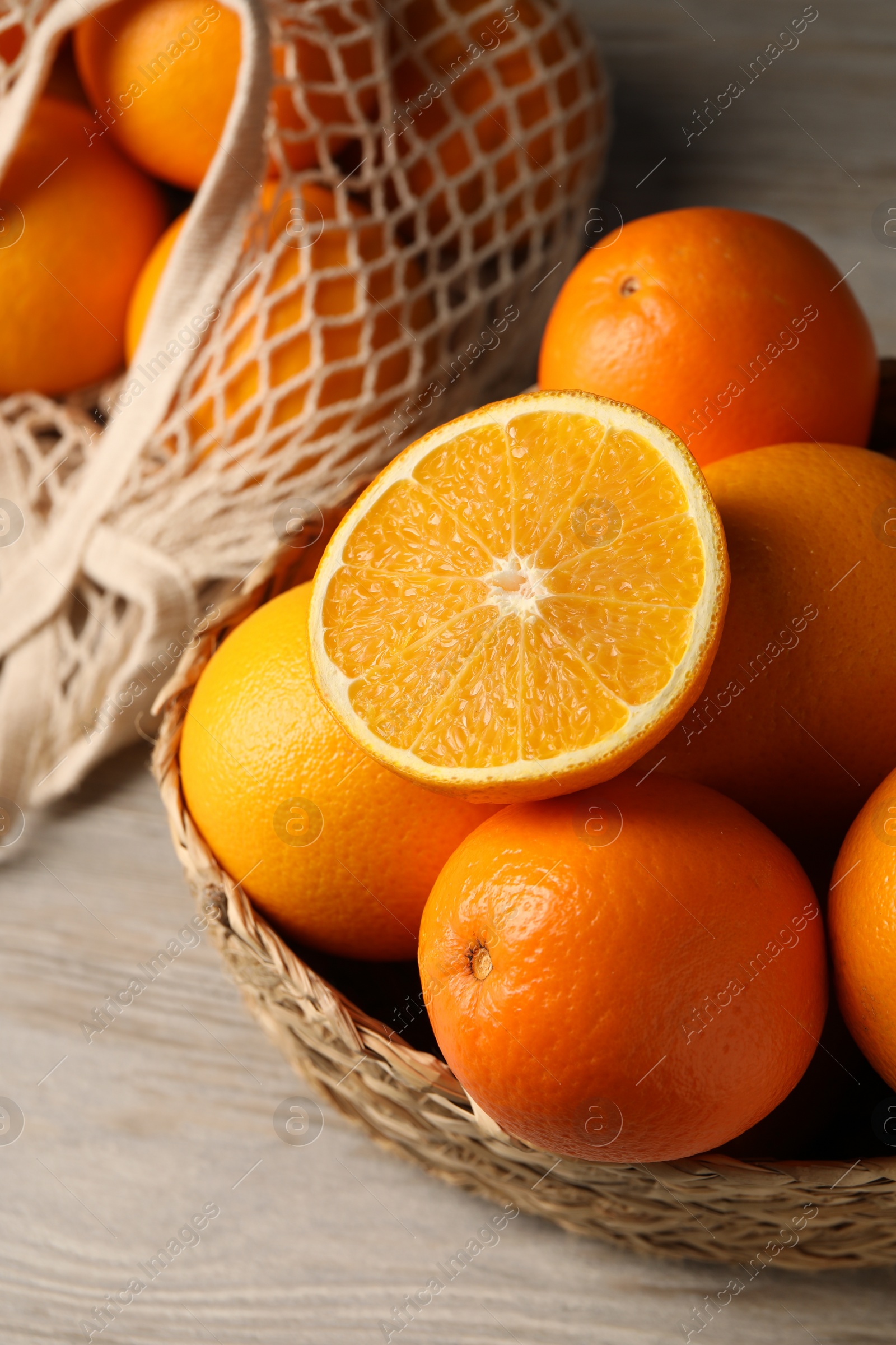 Photo of Many whole and cut oranges on wooden table