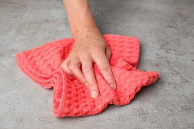 Photo of Woman wiping stone surface with kitchen towel, closeup