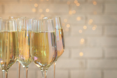 Glasses of champagne against blurred lights, closeup. Space for text