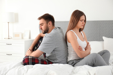 Photo of Unhappy couple with relationship problems after quarrel in bedroom