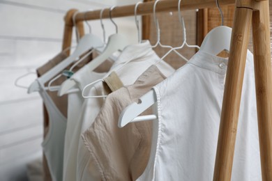 Photo of Rack with stylish women's clothes in dressing room, closeup