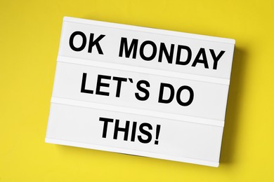 Lightbox with motivational quote Ok Monday Let's Do This! on yellow background, top view