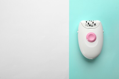 Modern epilator on color background, top view. Space for text