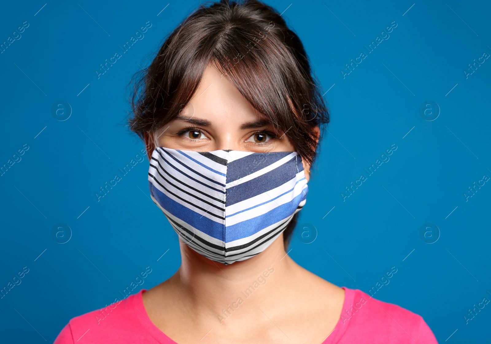 Photo of Young woman in protective face mask on blue background