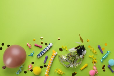 Photo of Flat lay composition with carnival items on green background. Space for text