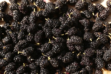 Delicious ripe black mulberries on table, flat lay