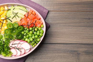 Photo of Delicious salad with salmon and vegetables on wooden table, top view. Space for text