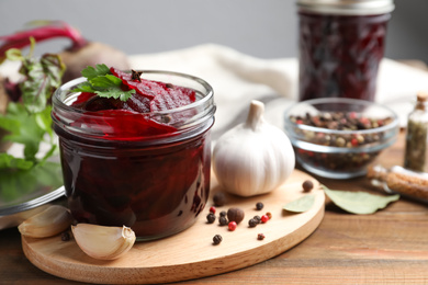 Delicious pickled beets and spices on wooden table