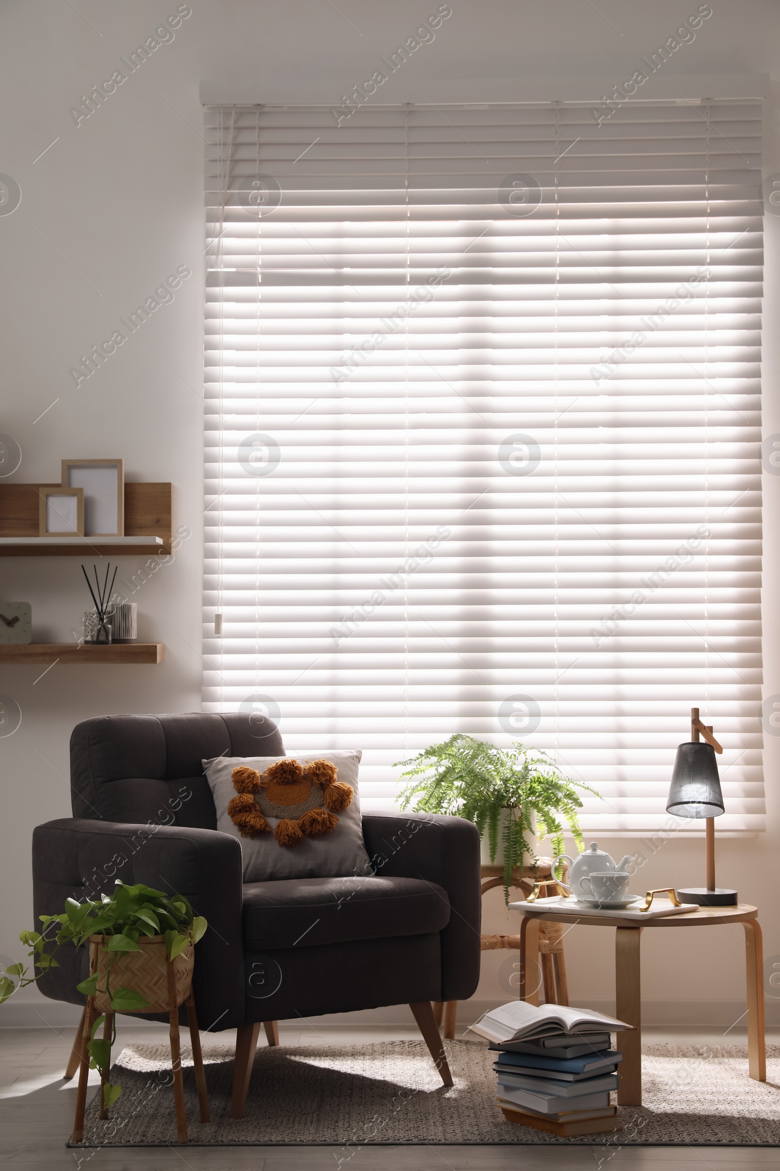 Photo of Comfortable place for rest with armchair near window in room