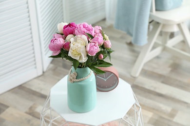 Photo of Vase with bouquet of beautiful peonies on table in room. Space for text