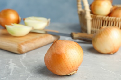 Photo of Ripe onion on grey table, space for text
