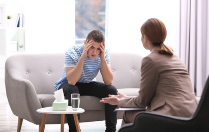 Psychotherapist working with young man in office
