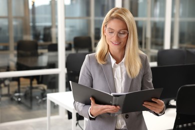 Photo of Smiling woman with folder in office, space for text. Lawyer, businesswoman, accountant or manager