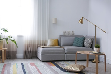 Photo of Modern living room interior with comfortable sofa near window