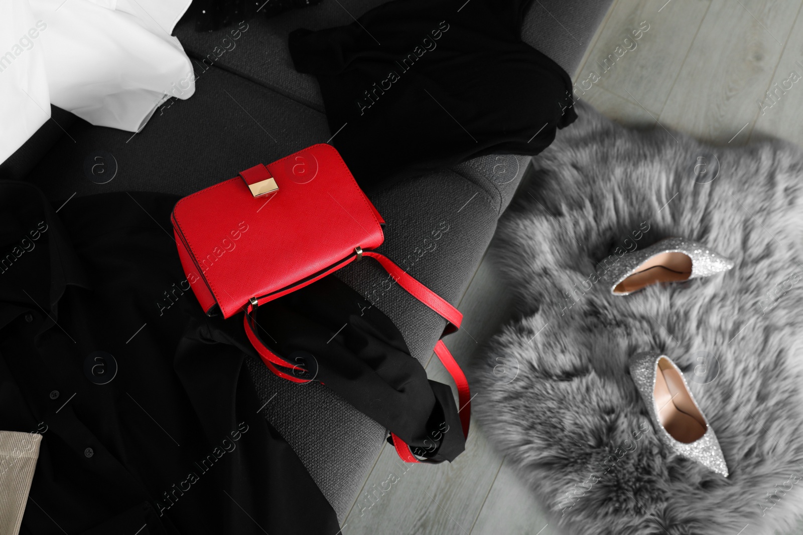 Photo of Pile of and bag clothes on sofa indoors, top view